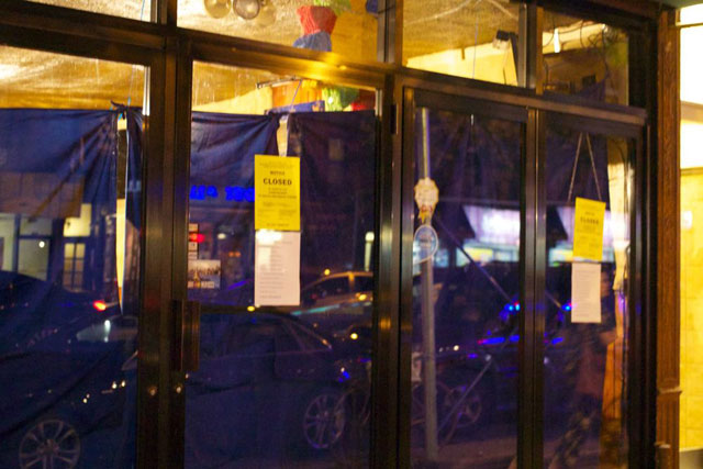 The covered windows with health department notices of El Azteca