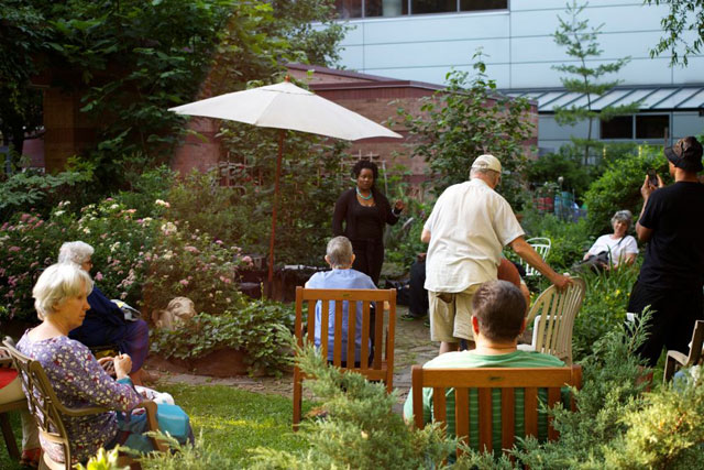 The audience watching the performance at the Oasis Community Garden