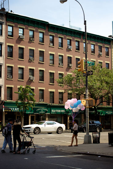 A girl holding a large bunch of balloons