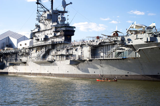 A group of rowers next to the Intrepid