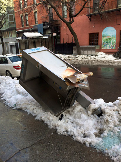 A knocked over and smashed phone booth